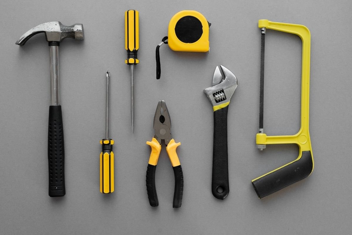 A collection of various tools arranged neatly on a gray surface, showcasing their different shapes and sizes.